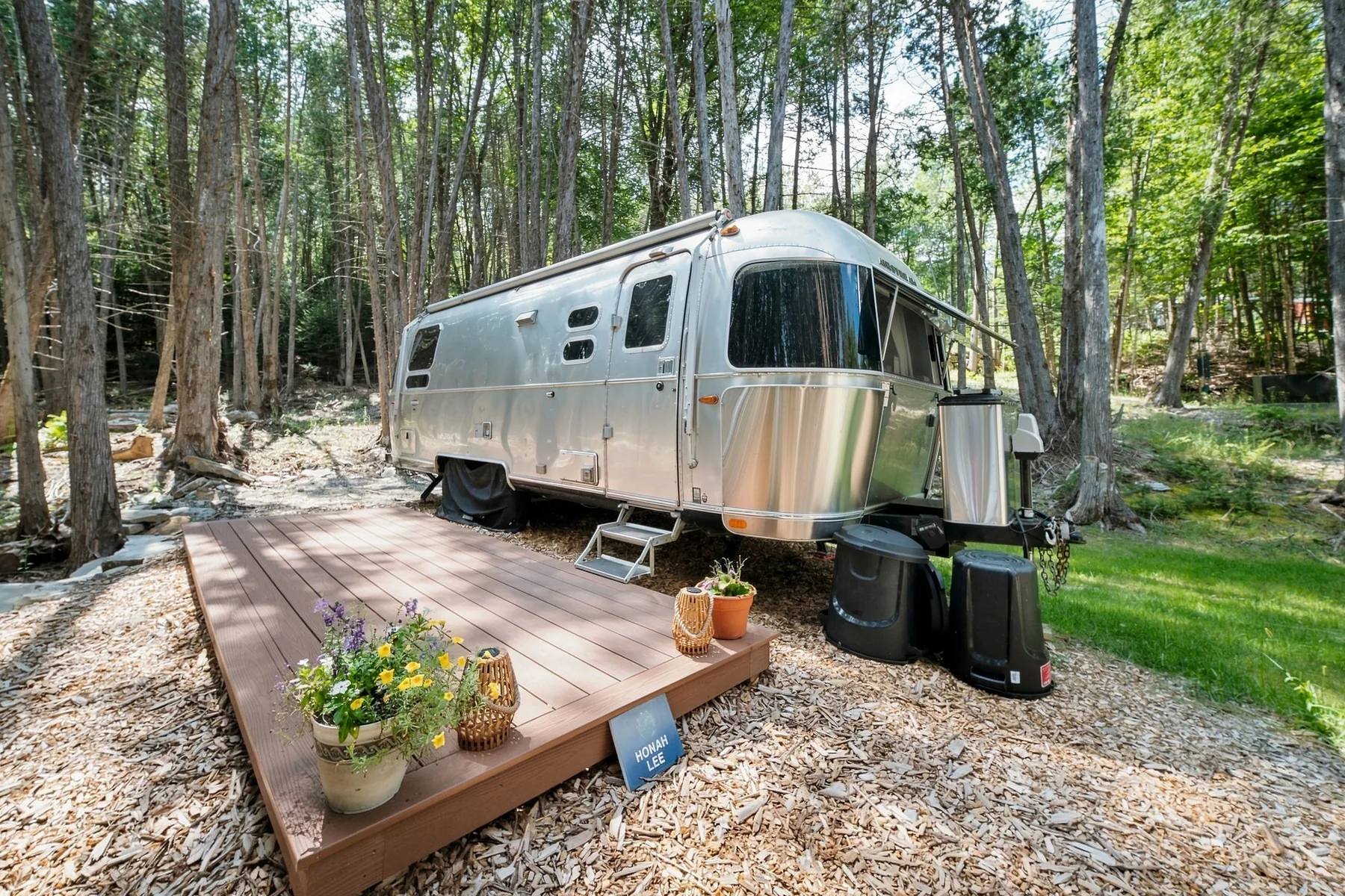Polished Airstream guest space set among the trees