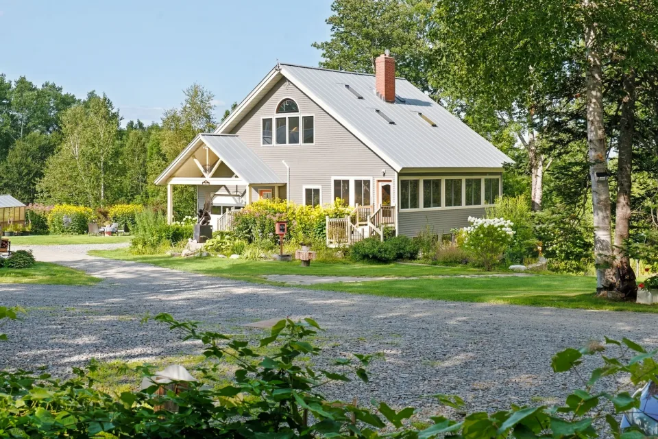 Dragonwood main house framed by summer gardens in Parkman, Maine
