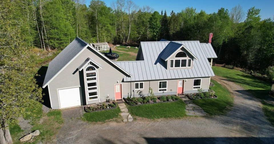 Aerial photograph of a Maine waterfront home at sunset by Muyinza Kasirye
