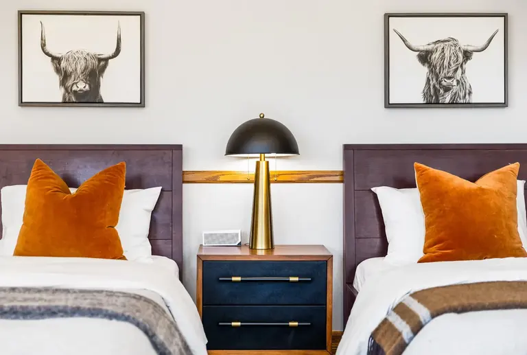 Furnished twin bedroom with balanced artwork and lighting